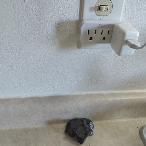 Three shungite stones on countertop.